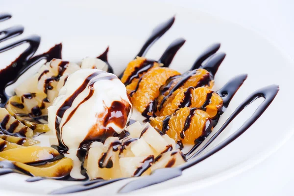 Sweet dessert: ice cream with fruit and chocolate topping on white background