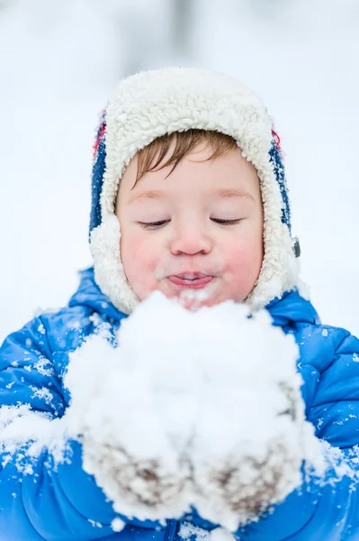 Zewnątrz portret szczęśliwy dziecko śnieg wiejący w winter park — Zdjęcie stockowe