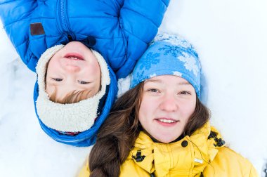 Açık portre mutlu anne ve bebek kar kış park ve smili altında yatan