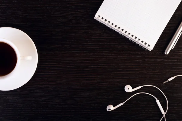 Kopje warme koffie, hoofdtelefoon, notebook, pen op de houten achtergrond. Plaats voor tekst. Vierkant plaatje. — Stockfoto