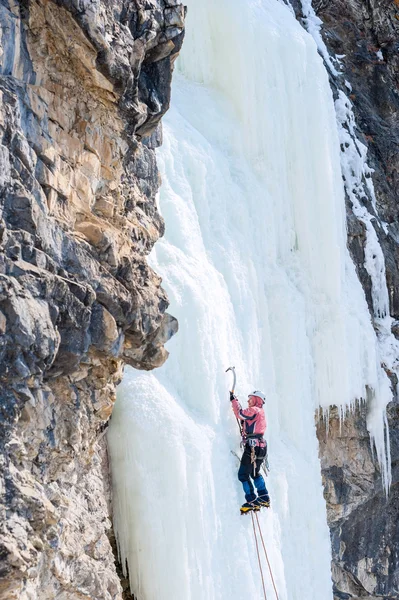 Fille alpiniste escalade une cascade gelée et souriant — Photo