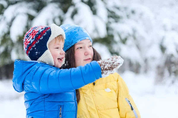 Портрет матери и ребенка, гуляющих в парке зимой. Сын показывает свою руку. — стоковое фото