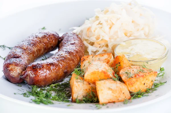 Rosto et sosis patates ve beyaz zemin üzerine lahana ile — Stok fotoğraf