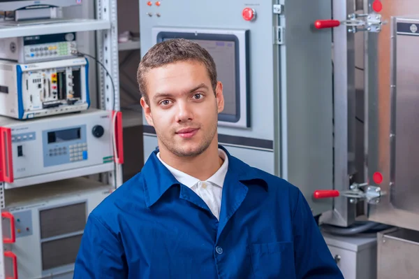 Jonge ingenieur in een wetenschappelijk laboratorium op de achtergrond van de vacuumdoos — Stockfoto