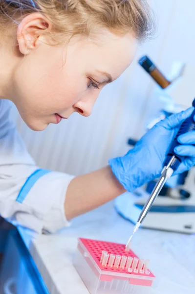 Vrouw wetenschapper scheikundige met een pipet in hand maakt de analyse in het moderne laboratorium — Stockfoto