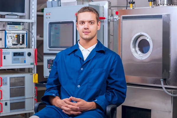 Jonge ingenieur in een wetenschappelijk laboratorium op de achtergrond van de vacuumdoos — Stockfoto