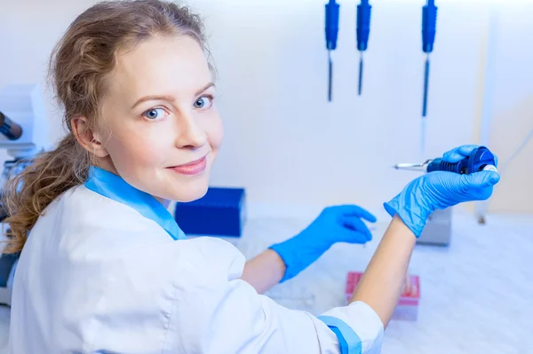 kadın bilim adamı kimyacı Pipetler ve çalışma alanı'nı modern laboratuvar test tüpleri ile