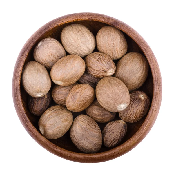 Nutmegs in a bowl over white — Stock Photo, Image