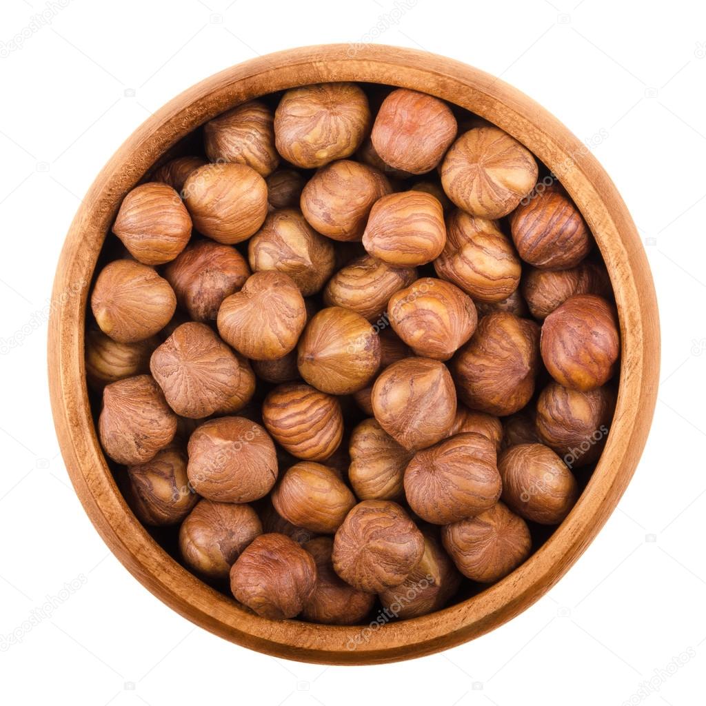 Hazelnuts in a bowl over white