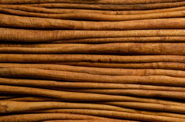Kurutulmuş tarçın kabuğu şeritleri. Tarçın verumunun içindeki kahverengi bir baharat, gerçek tarçın ağacı. Aromatik çeşni ve lezzet katkı maddesi. Yukarıdan yakın çekim, makro yiyecek fotoğrafı.