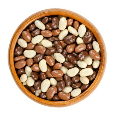 Kavrulmuş soya fasulyesi, çikolata kaplı, ahşap bir kasede. Kızarmış soya fasulyesi, siyah, süt ve beyaz çikolatayla kaplı. Yakın plan, yukarıdan, beyaz arkaplanda, makro yiyecek fotoğrafı.