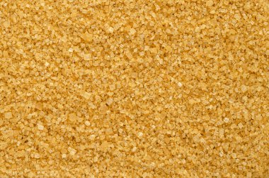 Esmer demerara şekeri, arka plan, yukarıdan. Kaba, kristal, doğal ve ham şeker, pekmez varlığından dolayı belirgin sarı-kahverengi renkli bir sakaroz şekeri. Arkaplan. Macro, yemek fotoğrafı..