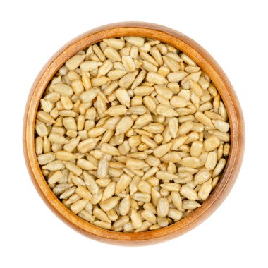 Kavrulmuş ve tuzlanmış, ahşap bir kasede Hulk ayçekirdeği. Çıtır çıtır çekirdekler, ayçiçeğinin meyveleri, Helianthus Annuus, atıştırmaya hazır. Yukarıdan yakın çekim, izole edilmiş makro yiyecek fotoğrafı.