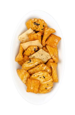 Senbei, Japon pirinç krakerleri, beyaz bir oval kasede. Ayrıca Sembe, çıtır çıtır, ısırık büyüklüğünde, çeşitli şekil ve boyutlarda tuzlu, soya sosu, mirin ve nori pullarıyla tatlandırılmış tuzlu atıştırmalıklar. Fotoğraf.