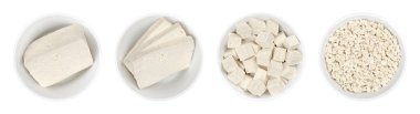 İşlenmiş beyaz tofu, beyaz kaselerde. Tek kalıp, üç dilim, küp ve parçalanmış tofu. Fasulye ezmesi, pıhtılaşmış soya sütü, Asya mutfağının bir bileşeni ve et yedeği. Yakın plan. Fotoğraf.
