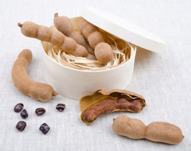 Dried Tamarind Fruits With Seeds In A Box On Linen clipart