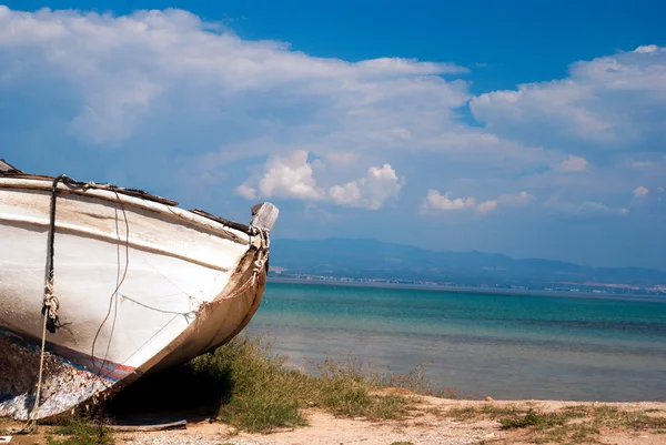 Старий човен на гальковому пляжі — стокове фото