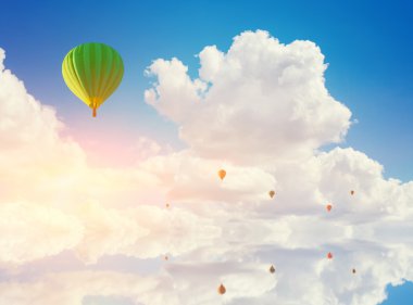 su üzerinde uçan renkli sıcak hava balonları