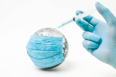 Covid-19 koruma konsepti: Doktorun Dünya 'ya koronavirüs aşısı enjekte etmesi beyaz arka planda tıbbi yüz maskesi ile kaplıdır. Koronavirüse karşı aşı ve aşı. 