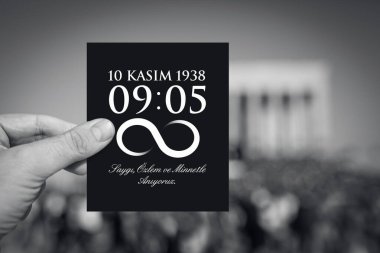 10 Kasım 'da Anitkabir mozolesi önünde, Türkiye Cumhuriyeti' nin kurucusunun ölüm saati ve tarihi yazılı siyah bir kağıt tutan erkek. Mesajın İngilizcesi: Sizi saygı, özlem ve minnettarlıkla hatırlıyoruz..