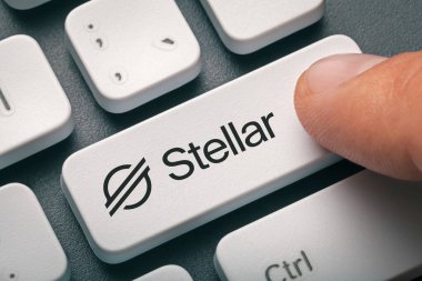 Kripto para ticareti kavramı: Stellar-124; Xlm logosu olan erkek el basımı bilgisayar anahtarı. Kripto para birimi madenciliği, ticaret, pazar konsepti.