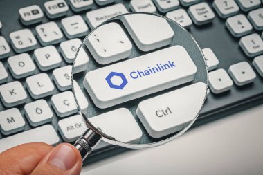 Kripto para ticareti kavramı: Büyüteç tutan erkek el ve zincirli bilgisayar anahtarı: Link logosu. Kripto para birimi madenciliği, ticaret, pazar konsepti.