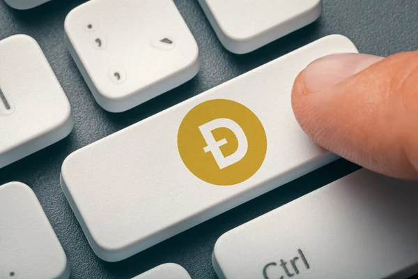 Dogecoin logolu bir erkek parmak bilgisayar tuşuna basıyor. Kripto para birimi miningi, ticaret konsepti.