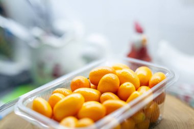 Sağlıklı beslenme kavramı: mutfak tezgahlarında plastik paketler halinde taze kumkatlar. Vitamin dolu organik yiyecekler.. 