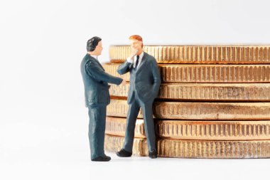 İki minyatür işadamı, beyaz arka planda kripto para yatırımı konusunda anlaşma yapıyor. Bir iş stratejisi geliştiriyorum. Kripto para birimi, engelleme zinciri veya ticaret konsepti.