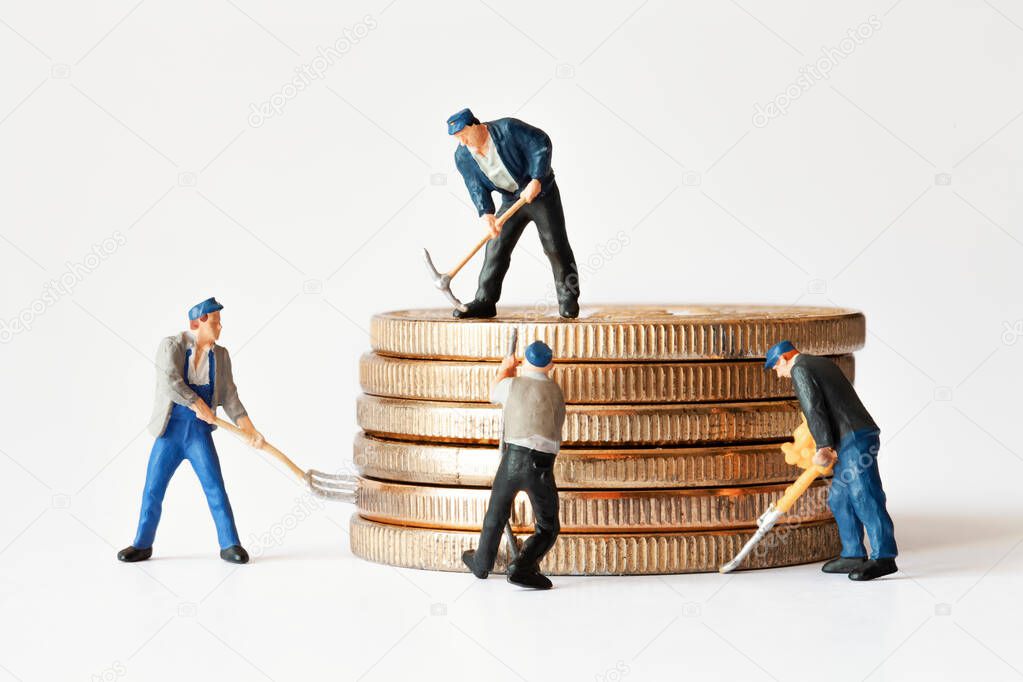 Group of miner figurines with equipment working on stack of bitcoins. Cryptocurrency, blockchain or trading concept.
