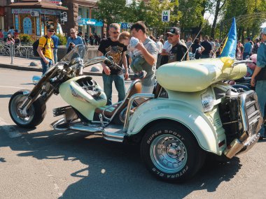 Kiev, Ukrayna-29 Nisan 2018: Bir grup insan, Ukrayna 'nın Kiev kentindeki Kreschatik caddesinde park halindeki muhteşem üç tekerlekli motosiklete bakıyorlar ve onları izliyorlar.. 