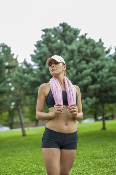 Jonge vrouw met een handdoek na sport activiteit — Stockfoto