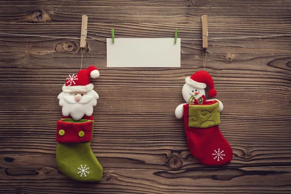 Empty xmas greeting card attached to clothespins between socks — Stock Photo, Image