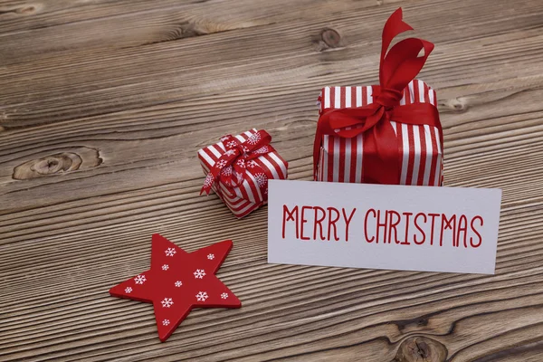 Veselé vánoční přání s dárkovými krabicemi — Stock fotografie