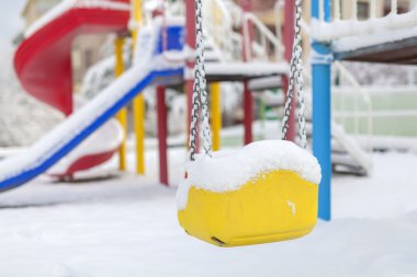 swing ve slayt Bahçesi, kışın kar kaplı
