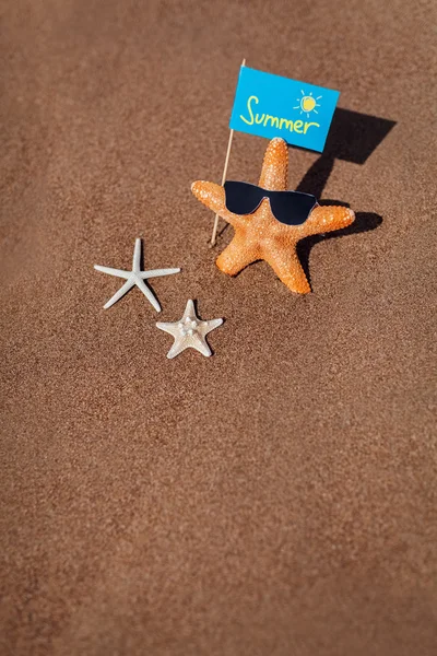 Três estrelas do mar e bandeira na areia. conceito de verão com cópia sp — Fotografia de Stock