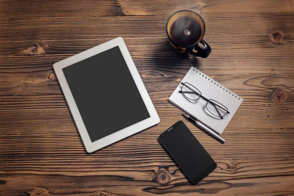 Tablet computador, telefone inteligente, xícara de café, bloco de notas e glasse olho — Fotografia de Stock