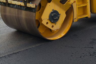 Yol silindiri yeni asfaltı düzleştiriyor