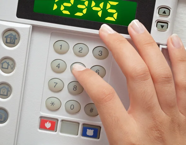 Woman entering security code to alarm system — Stock Photo, Image