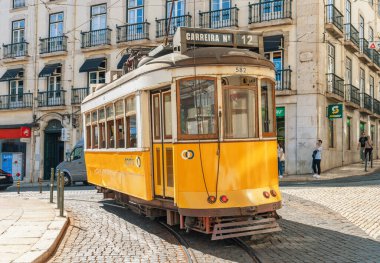 LISBON-PORTUGAL: 05 Ekim 2025: Stationary Carris Tram 12, Lizbon 'un Chiado bölgesinde raylarda bekliyor. İkonik tramvay kullanımı turistler arasında çok popüler bir ulaşım biçimidir..