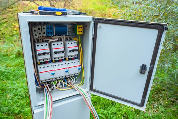 Electric panel on the street. Metal cabinet with electrical switches. Electric cabinet on background grass. Electrification cabinet. Concept for electrification of suburban housing. Electrical setup
