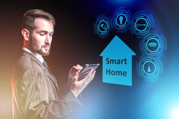 Using the Smart home system. A man controls the operation of systems in his home using a tablet computer. Home automation management system. Innovative technology.