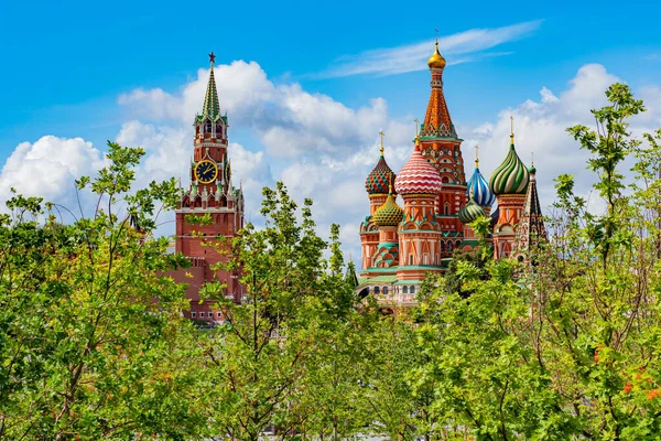 Moscow. Russia. Moscow on a Sunny day. Spasskaya tower of the Kremlin and St. Basil\'s Cathedral on a background of green trees. Business card of Russia. Moscow\'s kremlin. Temples Of Russia.