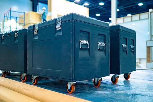 Transportation of musical equipment. Transportation musical instruments. Wardrobe trunks for the transport of sound equipment. Cases with equipment on the background of the stage under construction