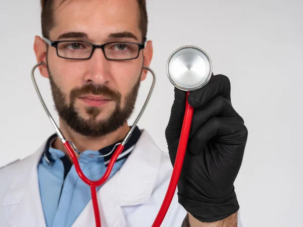 Doctor puts a stethoscope to screen. Concept - medical services. Medic with device for listening to heart. Doctor treats heart disease. He works in medical center. Medical examination.