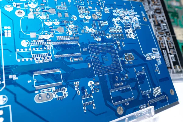 Blank motherboard for a computer. Blue circuit board close up. Motherboard computer board without processors. PCB without additional elements. Several PCBs stand side by side. PCB on a shop window