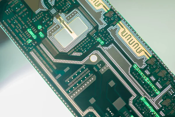 Printed circuit Board lies diagonally on the table. Gray-green background of a printed circuit Board with microchips. Production of printed circuit boards. Radio-electronic concept.
