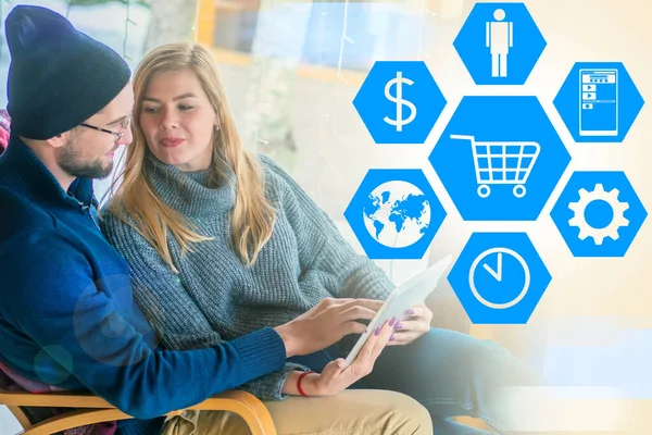 Convenient online store. Positive emotions from shopping on the Internet. A young couple is shopping online.The concept of online shopping. People with a tablet on the background of online store icons