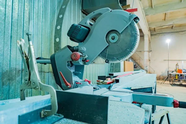 A circular saw for metal is installed in the workshop. Workbench with a circular saw. Circular saw for cutting metal. Machine for cutting metal workpieces.