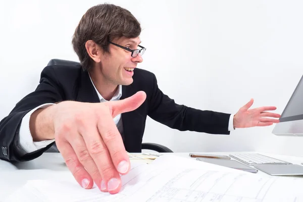 Satisfied investor next to computer. Man is happy about something. Concept - investor is satisfied with growth of shares. Office worker smiling. Happy office worker on white background.